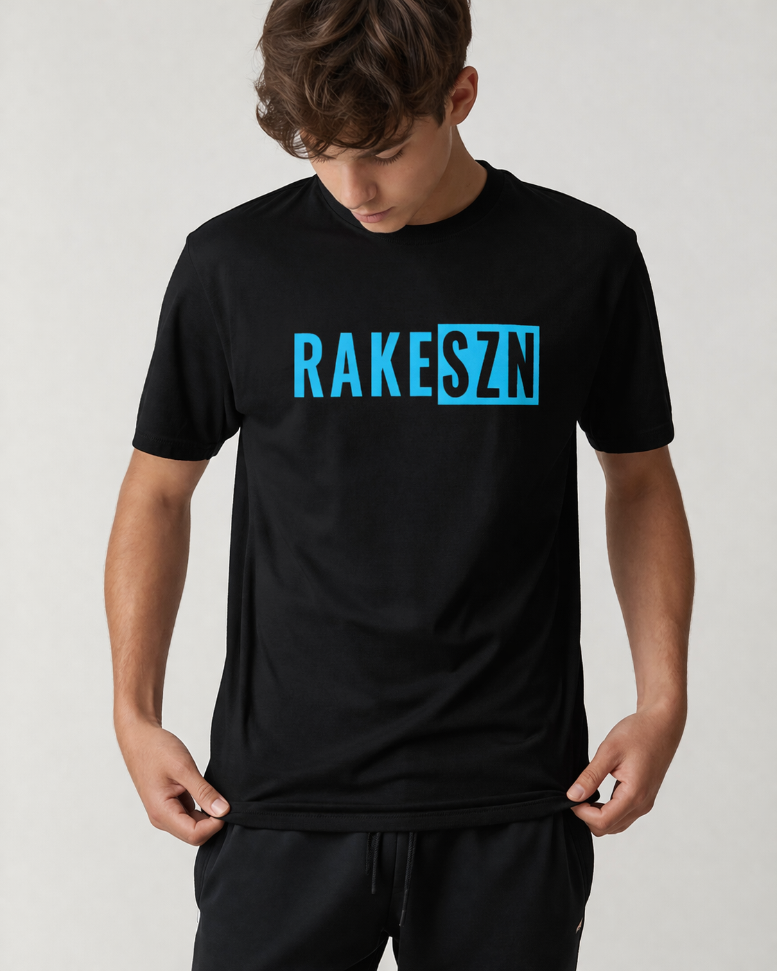 Model wearing the black RAKE SZN t-shirt by Rake City.