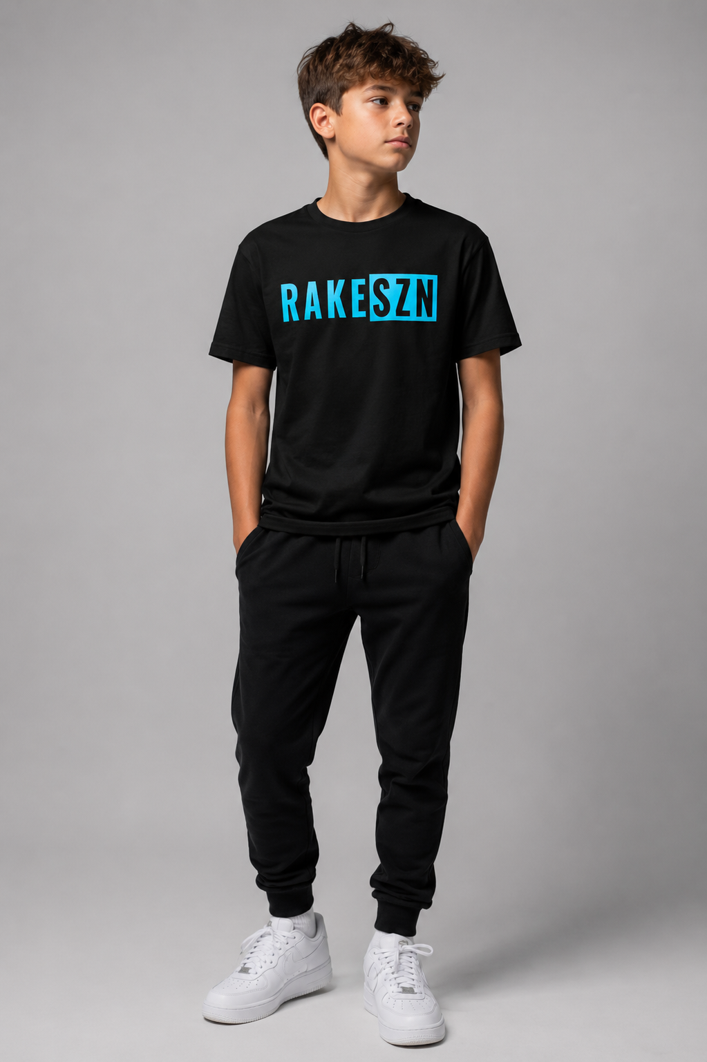 Model wearing the youth black RAKE SZN t-shirt by Rake City.