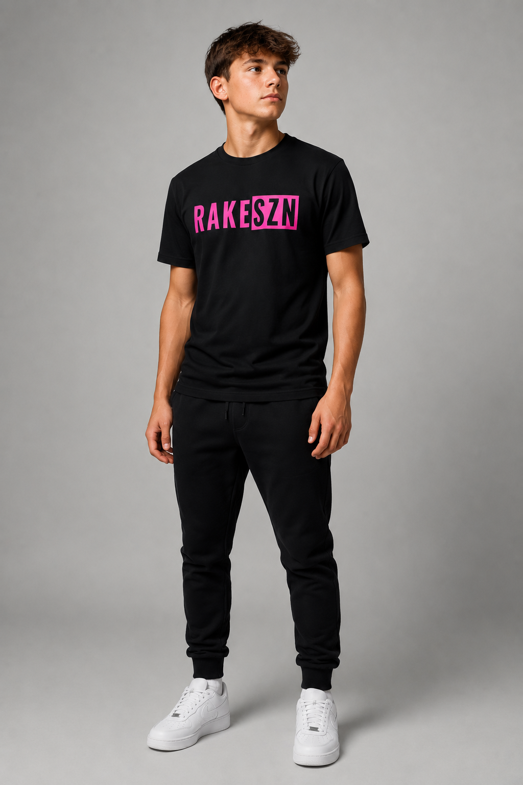 Model wearing the black RAKE SZN t-shirt with pink by Rake City.