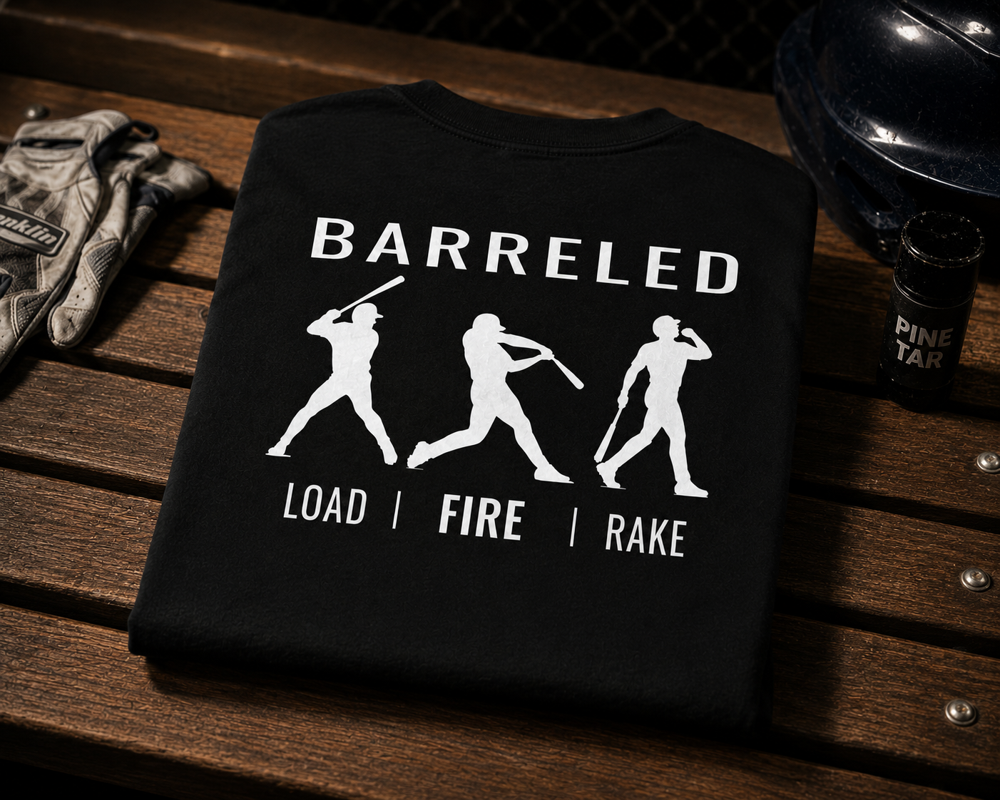 Folded dugout view of the youth BARRELED Baseball t-shirt by Rake City.