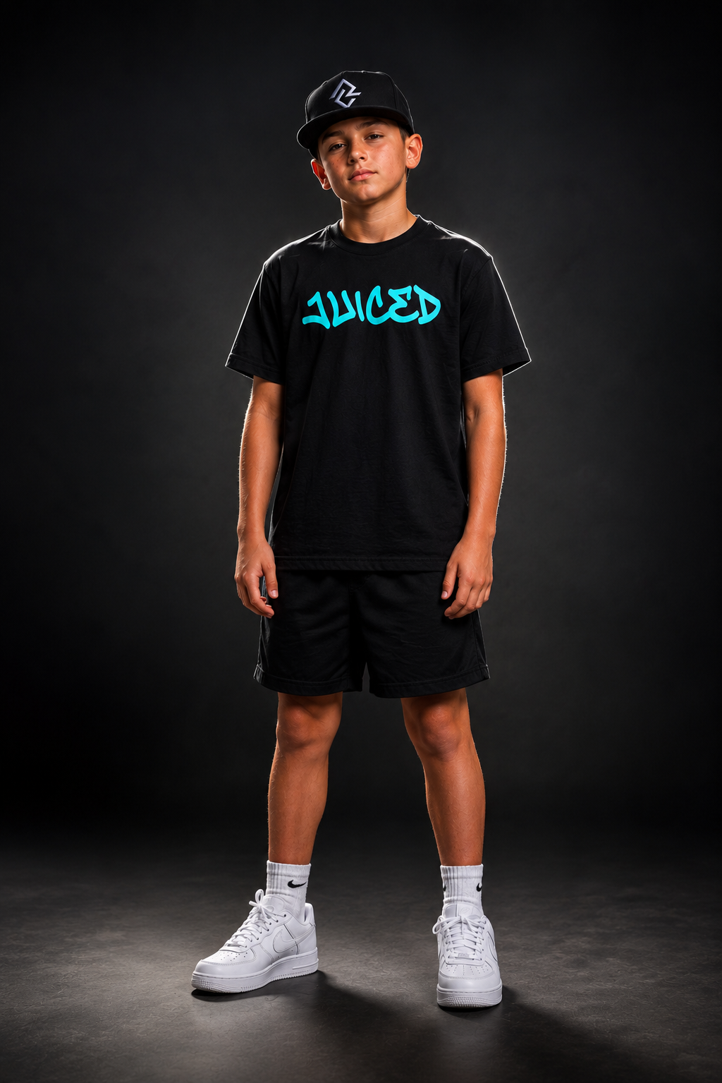 Model wearing the youth JUICED premium baseball t-shirt and RC snapback hat.